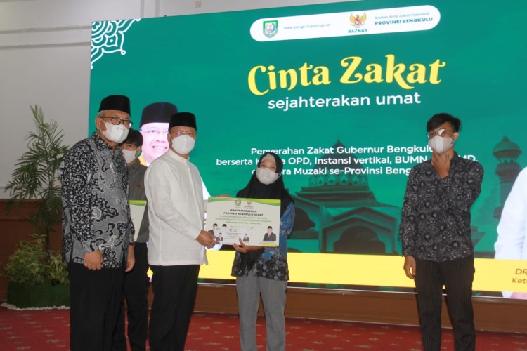 Gubernur Rohidin saat menyerahkan zakat secara simbolis kepada penerima zakat, Foto: Dok