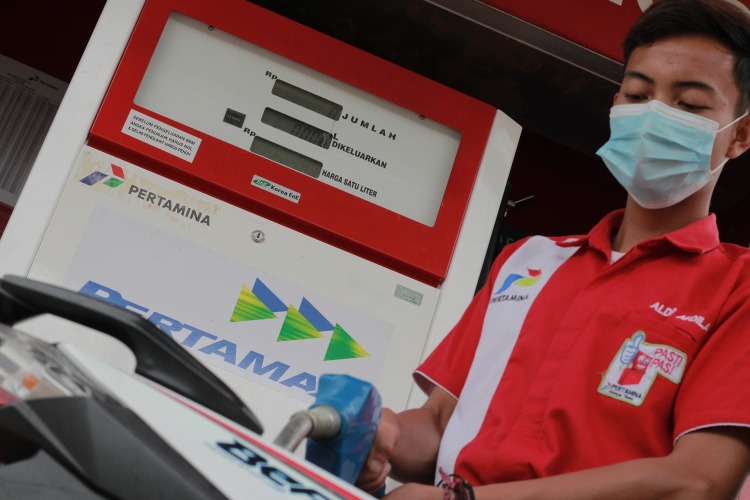 Petugas Pom SPBU sedang mengisi bahan bakar minyak, Foto: Dok/Irfan Arief