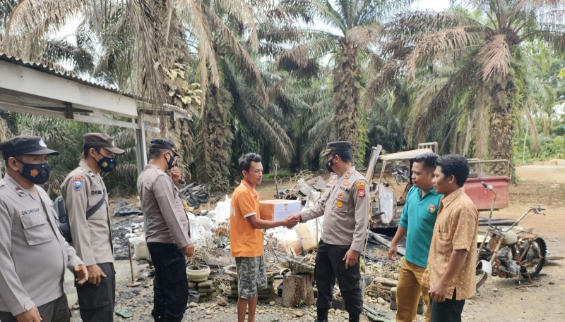 Kapolsek Mukomuko Selatan IPTU Firman Syahputra saat menyalurkan bantuan kepada Manuel (60) korban musibah kebakaran yang terjadi pada Sabtu, (08/10) lalu, Foto: Dok